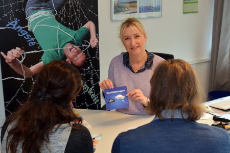 zu sehen ist Andrea Schadomsky im Beratungsgespräch mit einem Elternpaar